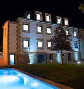 un edificio con una piscina delante de él por la noche en Beecaramulo-Apiturismo en Caramulo