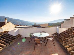 a patio with a table and chairs on a roof at Casa dos tinajas in Pinos del Valle