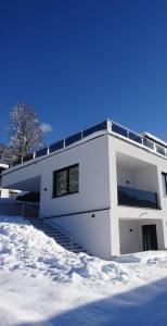 een wit huis met sneeuw ervoor bij Apartment Sabrina in Kitzbühel +7 foto's