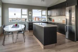 a large kitchen with a table and a refrigerator at Beautiful house in the nature of West Iceland in Borgarnes
