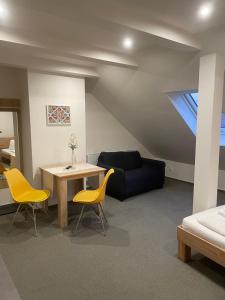 a living room with a couch and a table and chairs at Mikulov Inn - Apartments Slunce in Mikulov