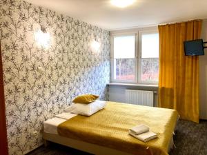 - une chambre avec un lit dans une pièce avec un mur dans l'établissement Sosnowe Zacisze, à Białystok