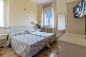 a small bedroom with two beds and a window at Hotel Villa San Giuseppe in San Bartolomeo al Mare