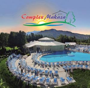 莫姆奇爾格勒的住宿－馬卡匝大廈旅館，享有带椅子的度假村的游泳池景致