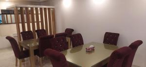 Center Point Apartment في داكا: قاعة اجتماعات مع طاولة وكراسي