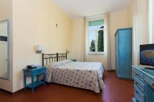 Schlafzimmer mit einem Bett, einem TV und einem Fenster in der Unterkunft Hotel Villa San Giuseppe in San Bartolomeo al Mare