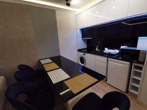 a small kitchen with a black counter and a microwave at Suncana planina apartman 103 in Kopaonik