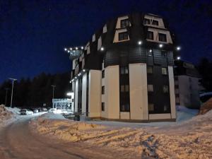 a large building in the snow at night at Suncana planina apartman 103 in Kopaonik