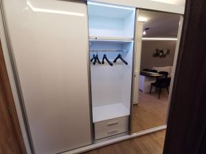 a sliding glass door with hangers and shoes at Suncana planina apartman 103 in Kopaonik