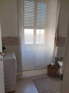 La salle de bains est pourvue d'une fenêtre, d'un lavabo et de toilettes. dans l'établissement CASA DEI PESCATORI, à Sanremo
