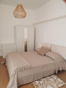- une chambre blanche avec un lit et un miroir dans l'établissement CASA DEI PESCATORI, à Sanremo