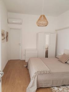 - une chambre blanche avec un lit et une lampe pendant dans l'établissement CASA DEI PESCATORI, à Sanremo