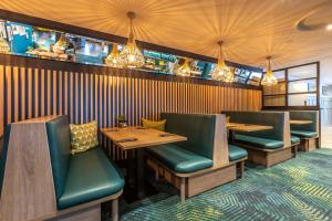 a restaurant with two tables and green chairs at Holiday Inn Oxford, an IHG Hotel in Oxford