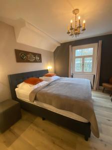 ein Schlafzimmer mit einem großen Bett und einem Kronleuchter in der Unterkunft Villa Burgau B&B in Monschau