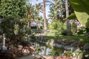 ogród ze stawem z drzewami i palmami w obiekcie Lovely 2 Bedroom Apartment w/ large garden + pools w mieście Benalmádena