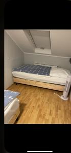 a small bedroom with a bed and a wooden floor at Barcelona . CHILLINGHOUSE # 10, 3 Min. von ICE, NETFLIX, Garten in Siegburg