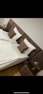 a bed with brown and white pillows on it at Barcelona . CHILLINGHOUSE # 10, 3 Min. von ICE, NETFLIX, Garten in Siegburg