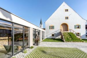 an external view of a white building with a church at Pöltnerhof in Weilheim in Oberbayern