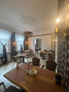 een eetkamer met tafels, stoelen en ramen bij Villa Burgau B&B in Monschau