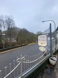 ein Schild an einem Zaun neben einer Straße in der Unterkunft Villa Burgau B&B in Monschau