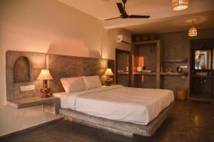 a bedroom with a large bed and two lamps at Silent Beach Resort in Mandrem