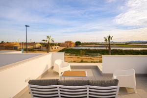 a balcony with white chairs and a table and a view at Villa Camilla in Roda