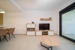 ein Wohnzimmer mit einem Tisch und einem TV in der Unterkunft Lo Romero in Pilar de la Horadada