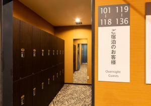 a row of lockers in a hallway with a sign at APA Hotel Kanazawa Ekimae in Kanazawa