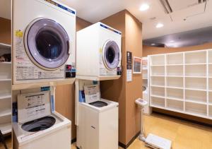 a laundry room with two washing machines and a washer and dryer at APA Hotel Kanazawa Ekimae in Kanazawa
