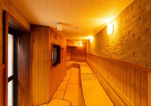 a sauna with a bench in a room with a tv at APA Hotel Kanazawa Ekimae in Kanazawa