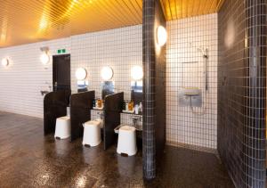 a bathroom with four urinals and a row of toilets at APA Hotel Kanazawa Ekimae in Kanazawa