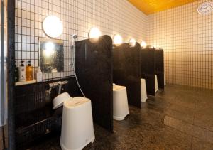 a bathroom with four urinals and a row of toilets at APA Hotel Kanazawa Ekimae in Kanazawa
