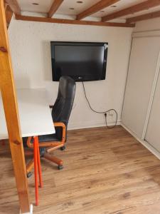 a room with a desk and a tv on a wall at Le Français, studio au calme proche de la gare in Besançon