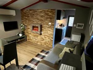 Apartment Eos في سترونجان: غرفة معيشة مع أريكة ومدفأة