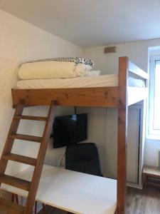 a room with a bunk bed and a desk and a computer at Le Français, studio au calme proche de la gare in Besançon