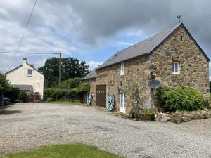 a stone house with a driveway in front of it at La grange in Taillebois