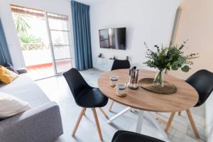 salon z drewnianym stołem i krzesłami w obiekcie Lovely 2 Bedroom Apartment w/ large garden + pools w mieście Benalmádena