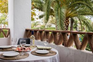 stół z kieliszkami do wina i jedzeniem w obiekcie Lovely 2 Bedroom Apartment w/ large garden + pools w mieście Benalmádena