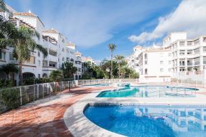 basen przed niektórymi budynkami w obiekcie Lovely 2 Bedroom Apartment w/ large garden + pools w mieście Benalmádena