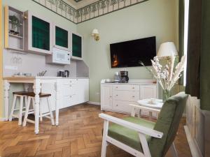 a kitchen with white cabinets and a table and a tv at Papiu 9 in Sibiu +49 photos