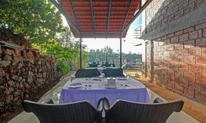 einen Tisch und Stühle auf einer Terrasse mit Ziegelwand in der Unterkunft Treebo Trend Raaya Regency in Mahabaleshwar