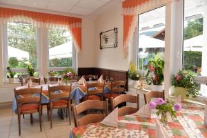 un restaurante con mesas, sillas y ventanas en Lotus en Plettenberg