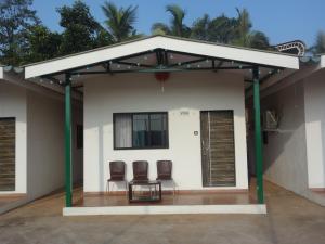 a small house with two chairs in front of it at Tent-O-Treat Premium Rooms near Dapoli in Dapoli