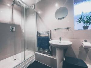 a bathroom with a sink and a shower at Modern 3 ground floor Parking and Garden in Bournemouth
