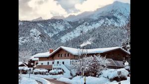 a house covered in snow in front of a mountain at Haus Amberger in Bayerisch Gmain