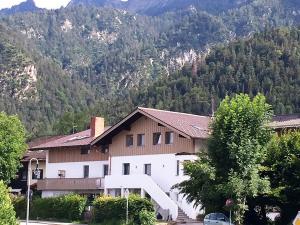 ein weißes Haus mit einem Berg im Hintergrund in der Unterkunft Haus Amberger in Bayerisch Gmain