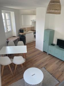 Lamballe plein centre, superbe appartement 1er étage في لومبال: مطبخ وغرفة معيشة مع طاولة وكراسي