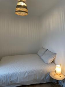 ein Schlafzimmer mit einem Bett und einer Lampe auf einem Tisch in der Unterkunft Lamballe plein centre, superbe appartement 1er étage in Lamballe