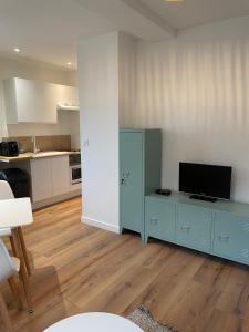 a living room with a blue cabinet and a kitchen at Lamballe plein centre, superbe appartement 1er étage in Lamballe