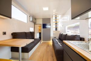 a kitchen and living room with a couch and a table at NAVIS SIREN Barco Apartamento in Baiona